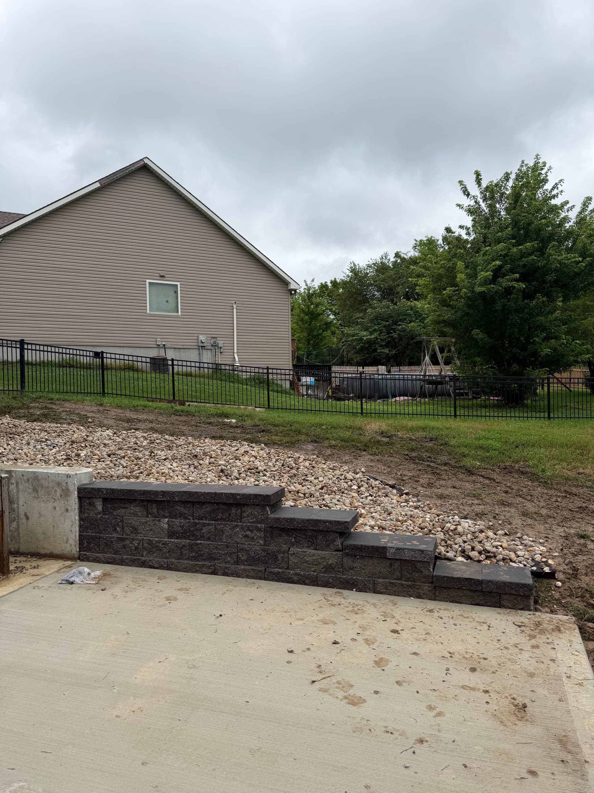 Patio Extension with Retaining Wall and Rock Bed in Platte City